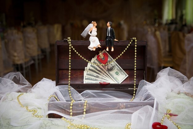 Figurines of the sitting bride and groom on a box