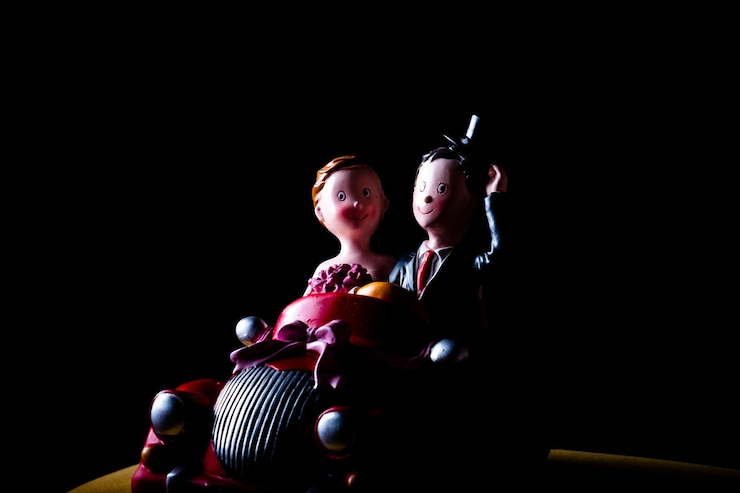 Photo figurines in toy car against black background