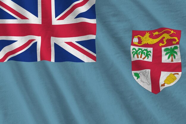 Fiji flag with big folds waving close up under the studio light indoors The official symbols and colors in banner