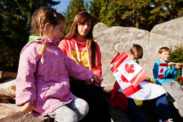 Fijne Canada-dag. Familie van moeder met drie kinderen houdt grote Canadese vlagviering in de bergen.