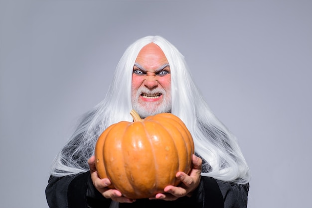 Fijne halloween boze tovenaar houdt pompoenman vast in heksenhoed traditionele voedselfantasie horror halloween
