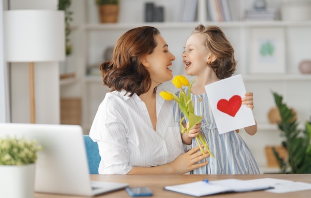 Fijne moederdag Kinddochter feliciteert moeder en geeft haar bloemen en kaart