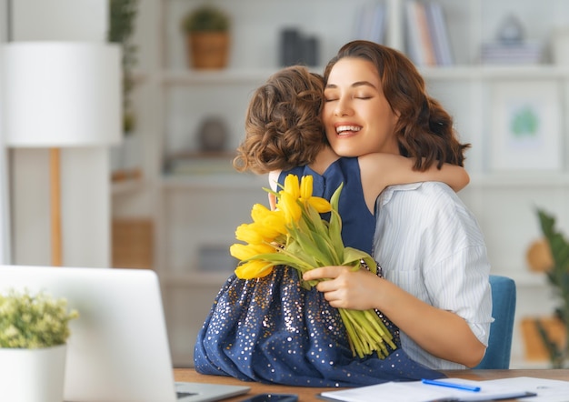 Fijne moederdag Kinddochter feliciteert moeder en geeft haar bloemen Moeder en meisje glimlachen