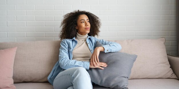 Foto fijne ontspannen afrikaanse vrouwenlounge op een comfortabele bank die thuis droomt