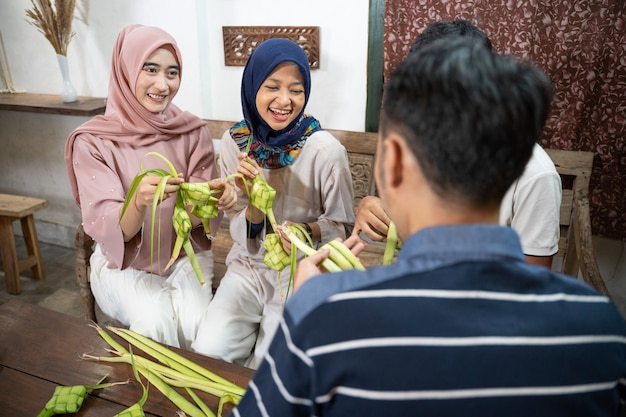Fijne opgewonden groep vrienden en familie die samen ketupat maken voor eid fitr mubarak of idul fitri lebaran traditie