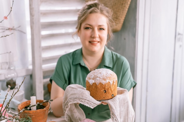 Foto fijne paasvakantie in het voorjaar mooie jonge huisvrouw vrouw houdt een versgebakken gebak cake of traditioneel brood in haar handen traditioneel handgemaakt eten feestelijk huisdecor