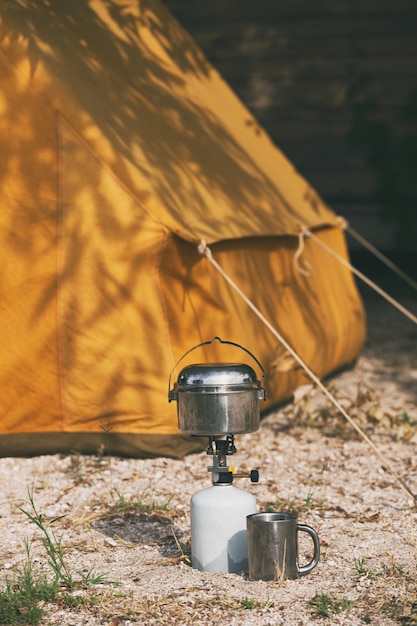 Foto fijne reis - brander, bowler, beker en vintage gele tent op de achtergrond