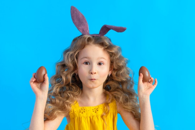 Fijne vakantie Pasen kinderen meisje in konijn haas konijnenoren en chocolade-eieren