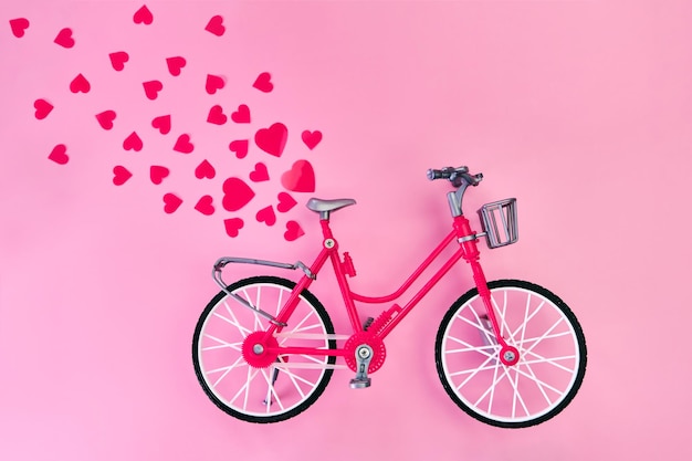 Fijne Valentijnsdag. Romantische achtergrond met rood vintage fietsspeelgoed en rode harten erop. Moederdag of Vrouwendag, wenskaarten, uitnodigingen en posters.