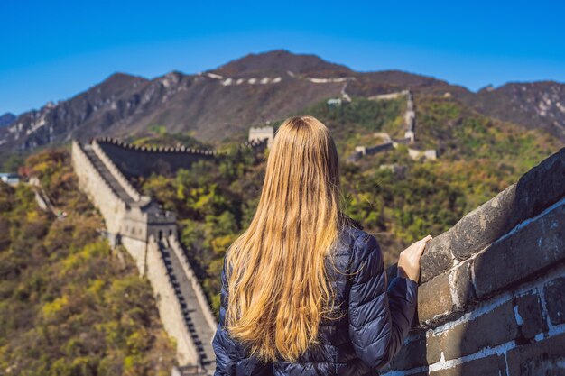 Fijne vrolijke, vrolijke toeristenvrouw bij de grote muur van china die plezier heeft op reizen, lachend lachend en