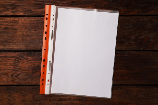 File folder with punched pockets on wooden table top view Space for text