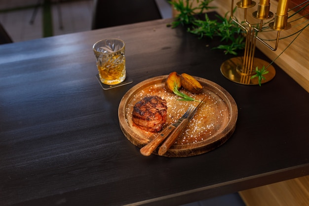 Filet mignon medium rare geserveerd op een houten bord met gebakken aardappelen