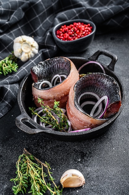 Filet van gezouten Hollandse haring in een pan met uien en tijm