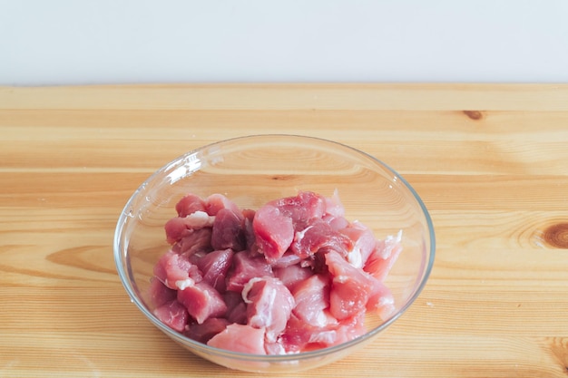 Filet van rauw vlees in een transparante plaat op een houten tafel close-up