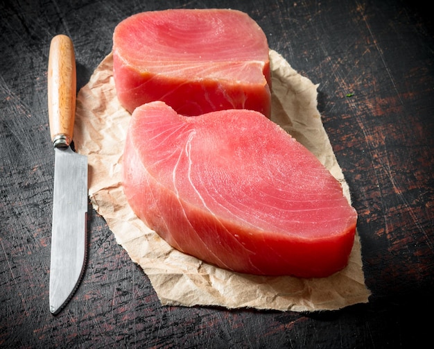 Filet van rauwe tonijn op het papier met een mes