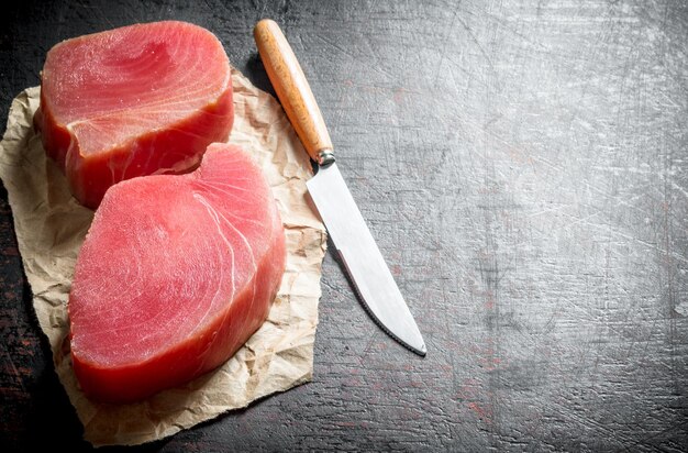 Foto filet van rauwe tonijn op het papier met een mes