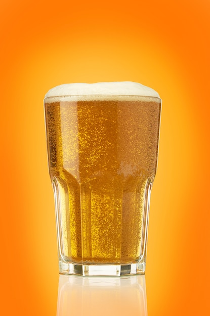 Наполненный свежим светлым пивом граненый стакан