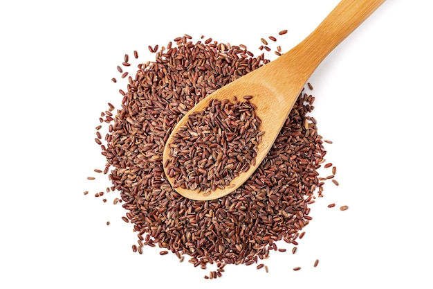 Filled wooden spoon with uncooked wild brown rice on heap cereal, isolated on white background.