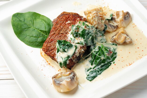 Fillet of beef with mushroom sauce on white plate