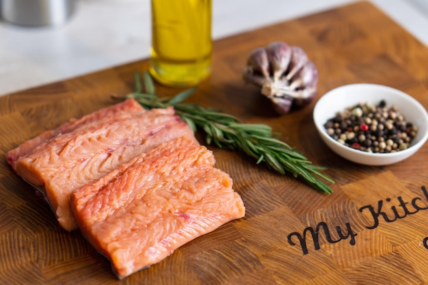 Photo fillet of red fish with rosemary for steaks on cutting board next to jar with spicesselective focs