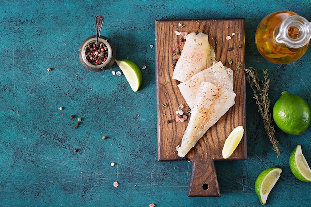 Fillet of white fish on a wooden board prepared for cooking. Flat lay. Top view