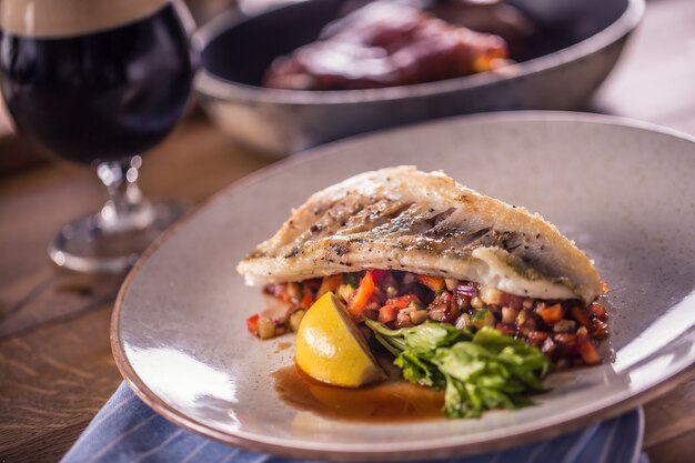 Fillet of zander with vegetables on a plate in a restaurant.