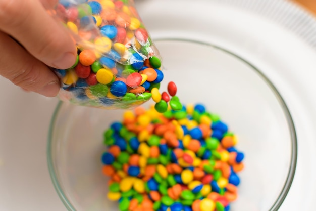 Filling bowl with with multicolored chocolate sprinkles to fill easter eggs