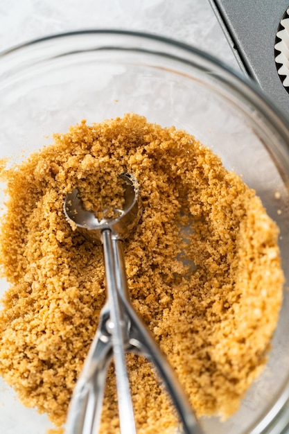 Filling cupcake liners with graham crackers to baking s'mores cupcakes