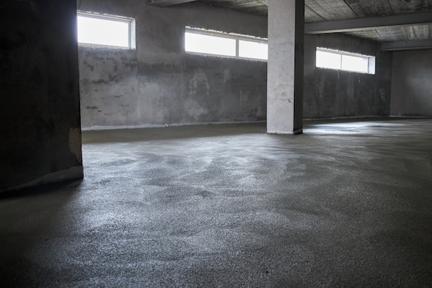 콘크리트로 바닥을 채우고 스크 리드 및 바닥을 평평하게합니다. 시멘트, 산업용 콘크리트의 혼합물로 만든 매끄러운 바닥