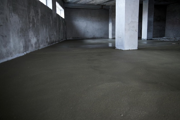 Filling the floor with concrete, screed and leveling the floor. Smooth floors made of a mixture of cement, industrial concreting