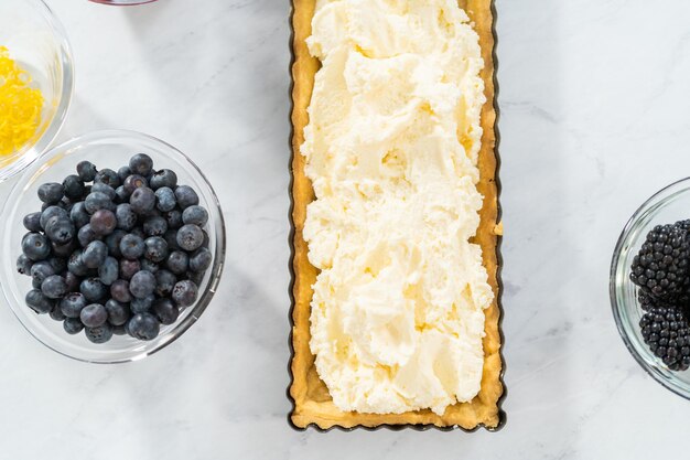 Filling mascarpone tart with cheese filling and decorating with fresh berries.