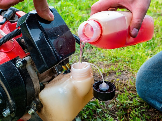 Photo filling the tank of a petrolpowered lawn mower