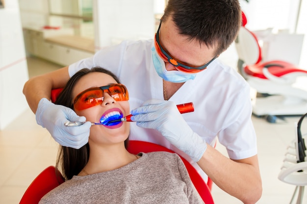 Filling teeth in a girl in dentistry.