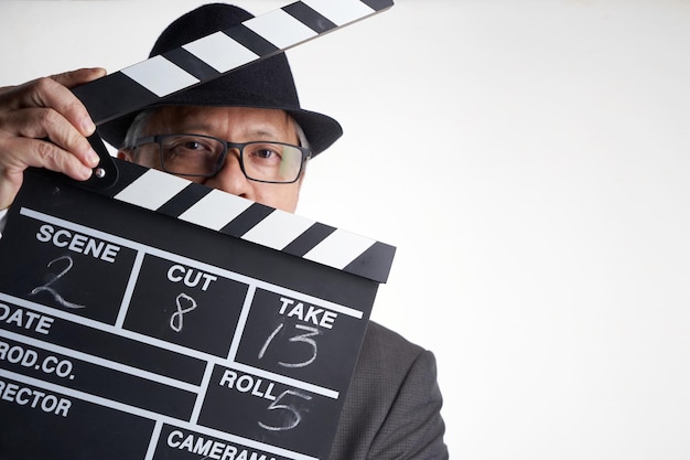 Film director holding clapper board against white
background