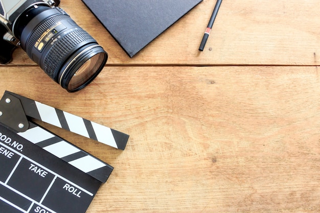 Film director's desk. clapboard, book and digital camera on wood table 