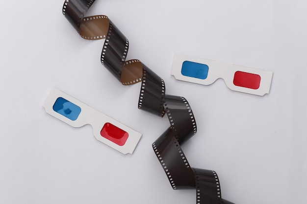 Film tape and 3d glasses on white background. ÃÂ¡inema, Entertainment industry. Top view