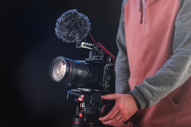 Filmmaker or cinematographer using professional camera gear to make documentaries and movies. Young cameraman, audiovisual, story telling and directing movies concepts.