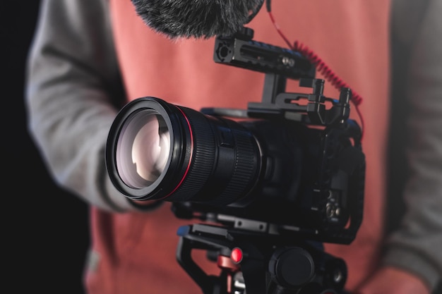 Filmmaker or cinematographer using professional camera gear to make documentaries and movies. Young cameraman, audiovisual, story telling and directing movies concepts.