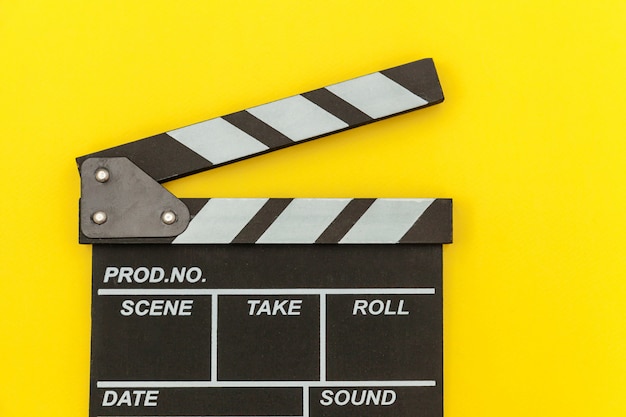 Filmmaker profession. Classic director empty film making clapperboard or movie slate isolated on yellow wall. Video production film cinema industry concept. Flat lay top view copy space .