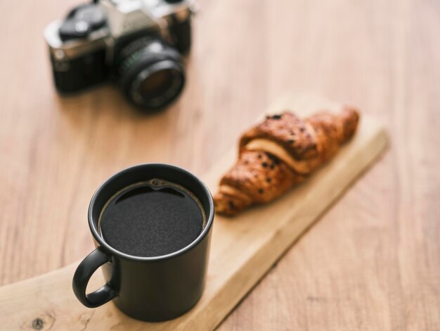 Filter koffie chocolade croissant en retro filmcamera op de houten tafel