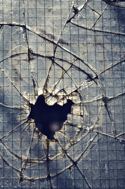 Photo filtered vintage photograph of hole in a broken security glass