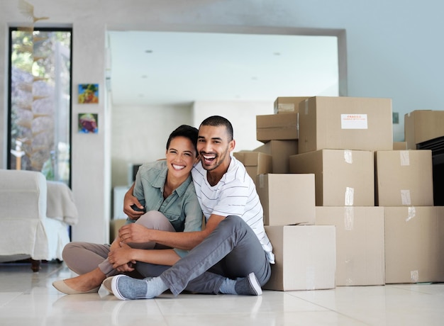 Finally a home of our own portrait of a happy young couple sitting on their living room floor on mov