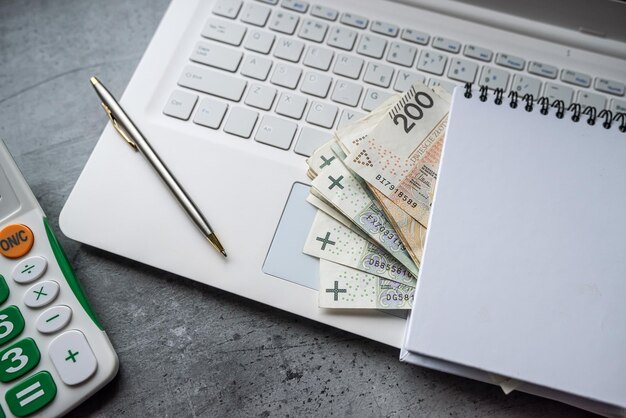 Foto finanze background pln zloty denaro con calcolatore notepad vuoto e portatile
