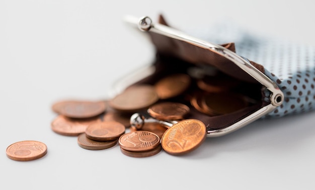 finance, cash, money saving and investment concept - close up of euro coins and wallet on table