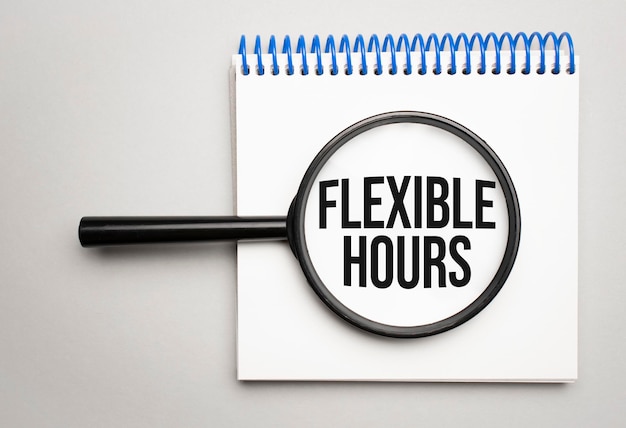 금융 및 경제 개념입니다. 텍스트 안에 FLEXIBLE HOURS라고 쓰여진 흰색 배경의 돋보기