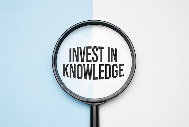 Finance and economics concept. Magnifier on a white background, inside the text is written Invest In Knowledge