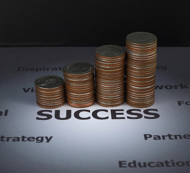 Photo finance and investment concept stack of coins on success word which surround with other factor to make success earn many money when success