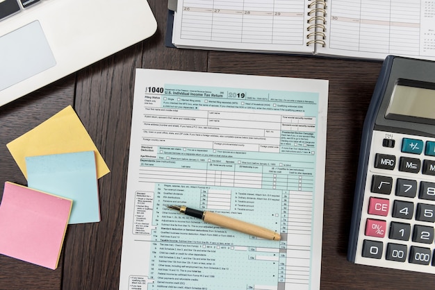 finance tax form with calculator, laptop and pen