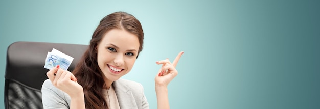 finances, people, savings and investment concept - happy business woman with euro cash money over blue background