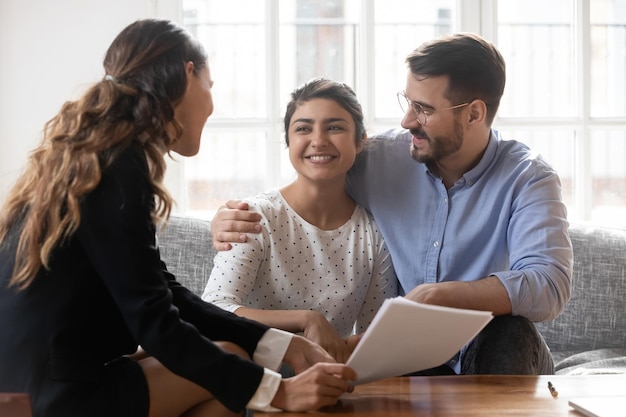 financial advisor consulting diverse young family couple about deal